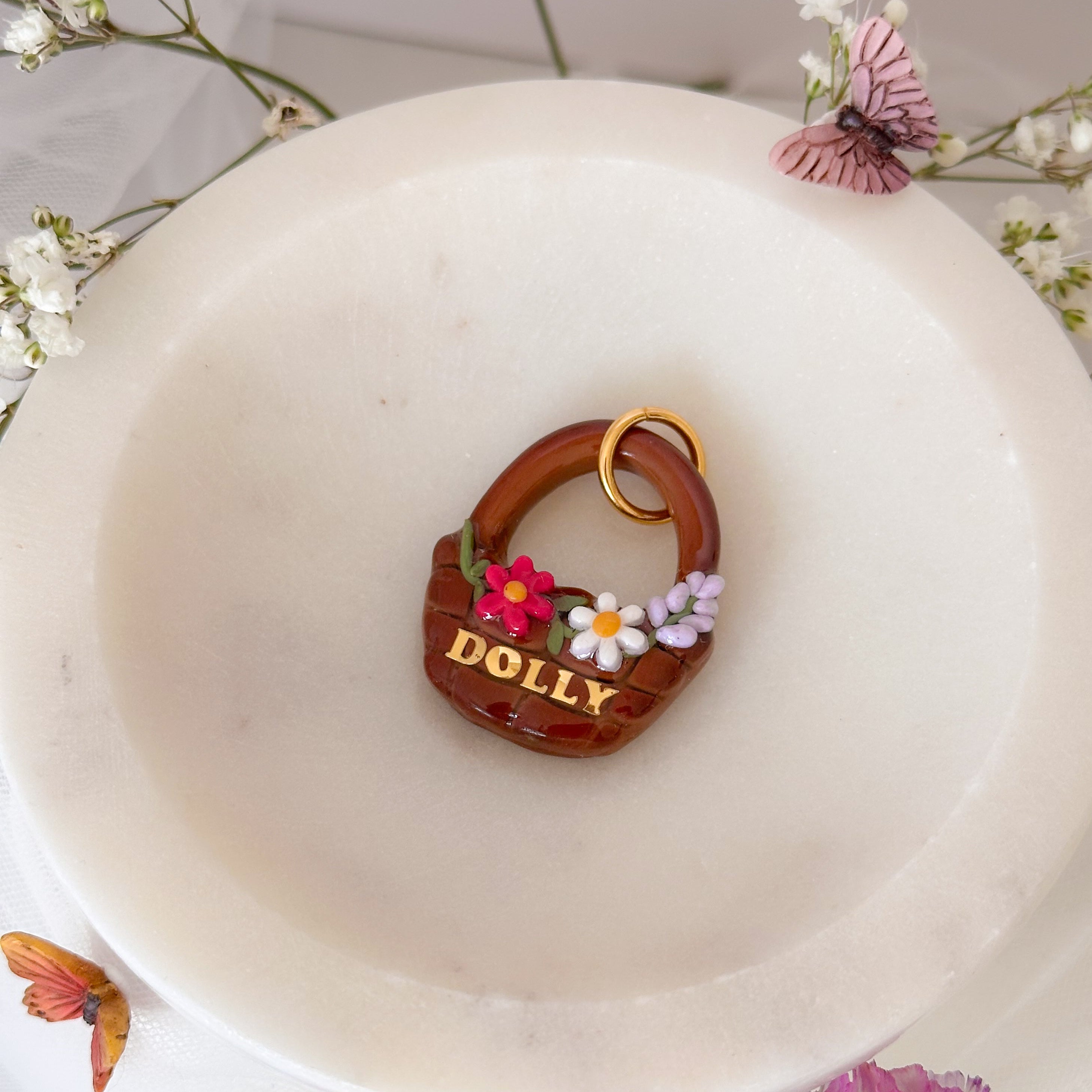 decorative pet id tag with flowers on a white plate surrounded by flowers and butterflies